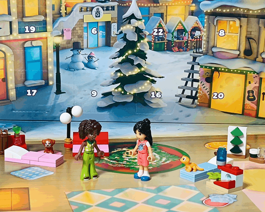 LEGO Friends 42668 アリヤとリアンが室内で並んで立つシーン。背景にクリスマスツリー、近くにアイラとポップコーンのフィギュアがいる。